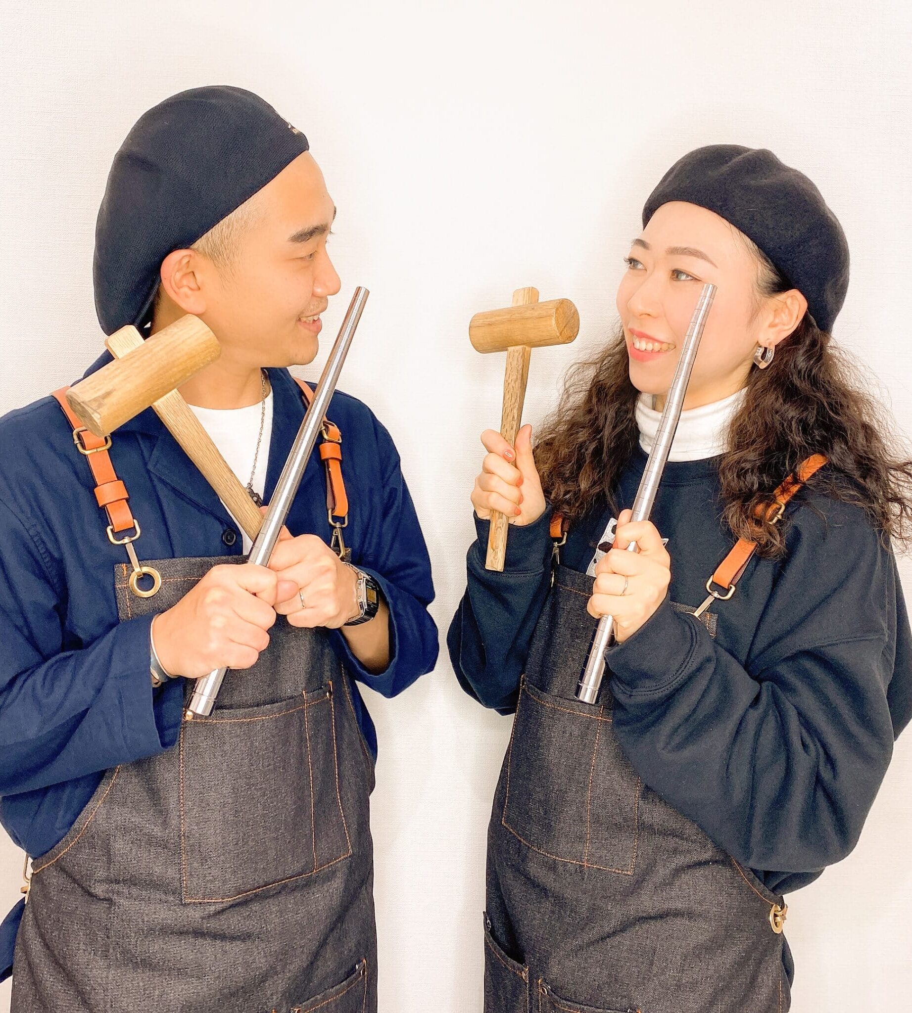 木槌とリング棒を持ち笑顔で見つめ合うカップル